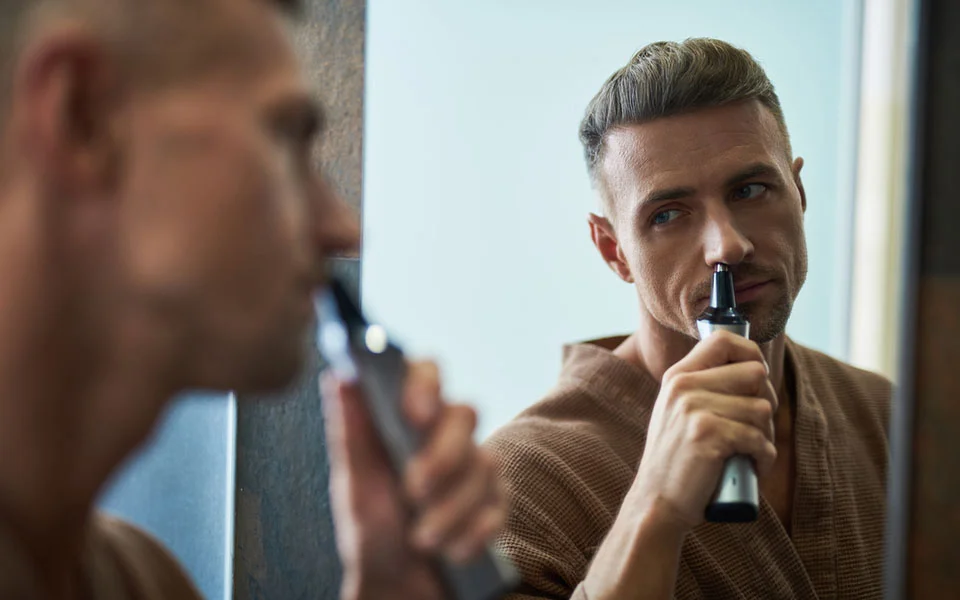 Man using nose hair trimmer
