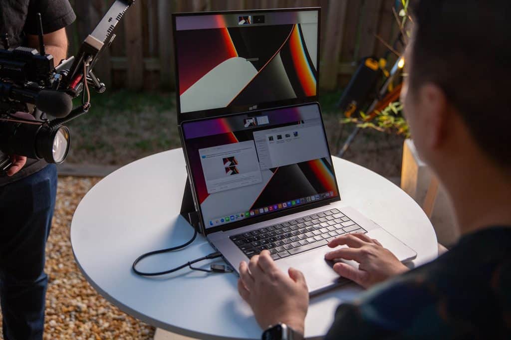 Foldable second screen attached to a laptop for enhanced productivity.